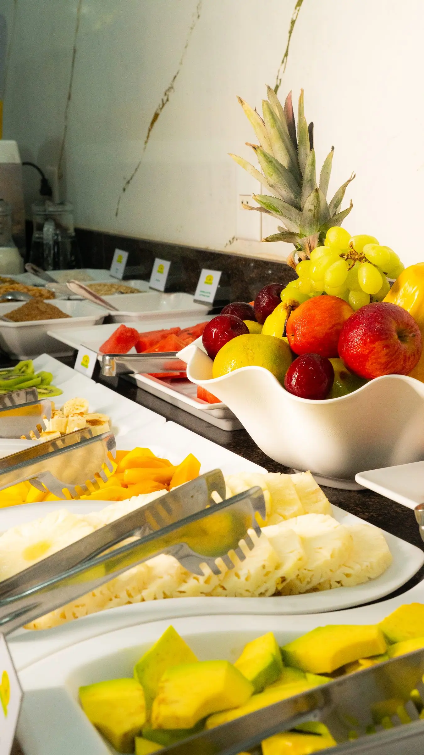 Buffet do café da manhã com cesta de frutas e frutas fatiadas