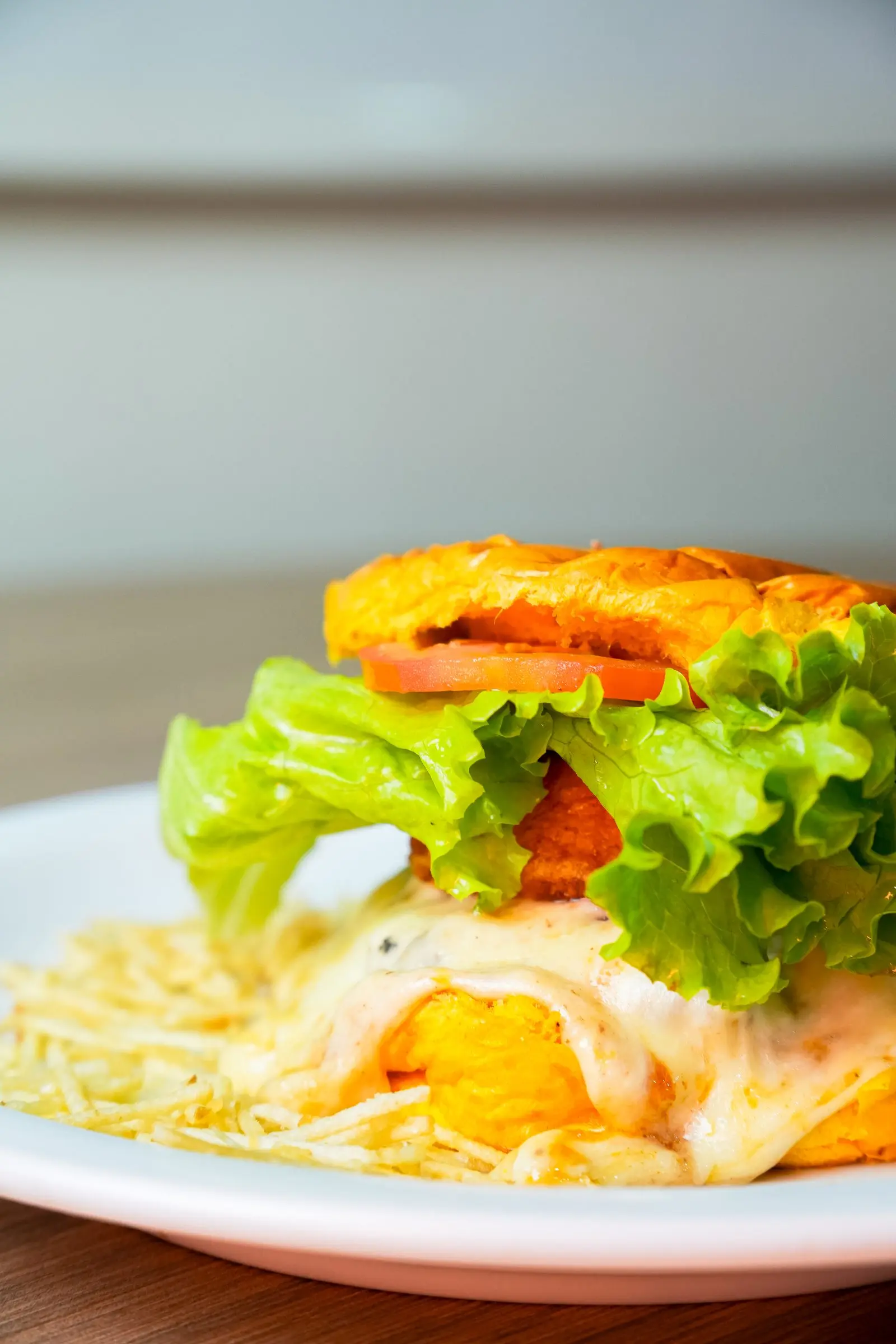 Lanche com alface, tomate, ovo e batata palha servido no prato