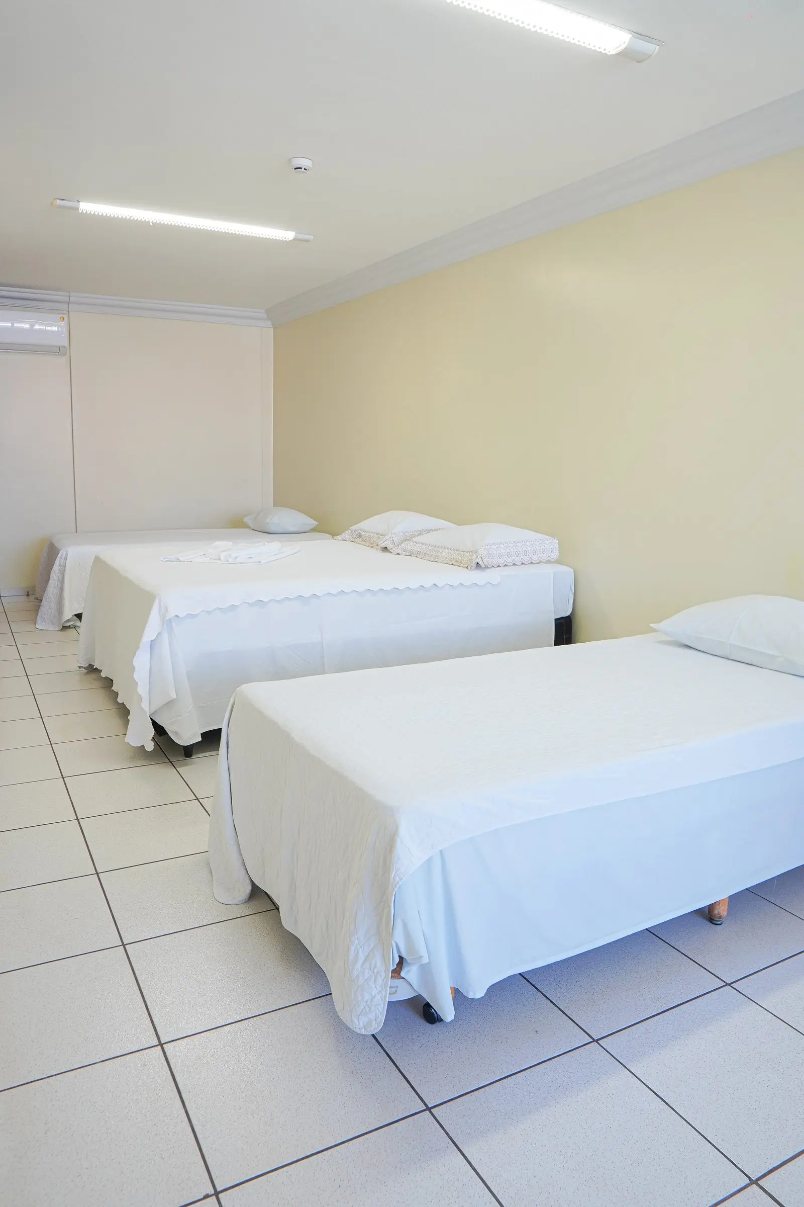 Quarto Quádruplo com camas arrumadas lado a lado