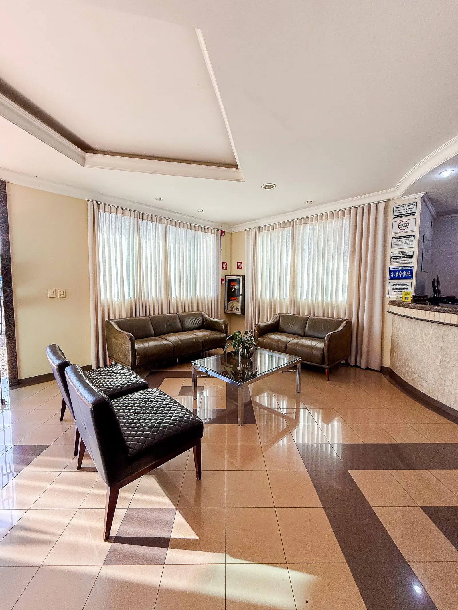 Recepção com sala de estar, sofás e poltronas de couro