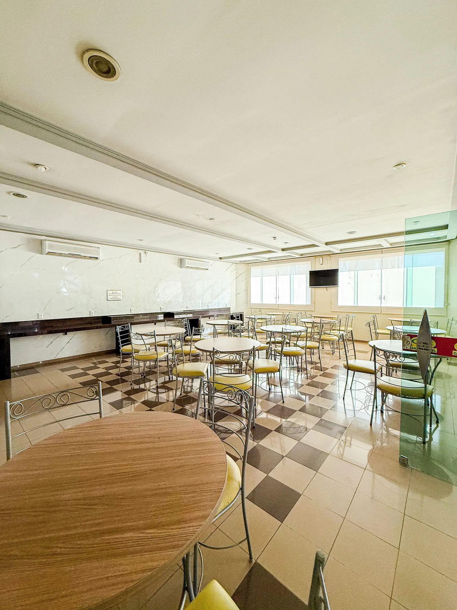 Salão do restaurante com mesas redondas e cadeiras