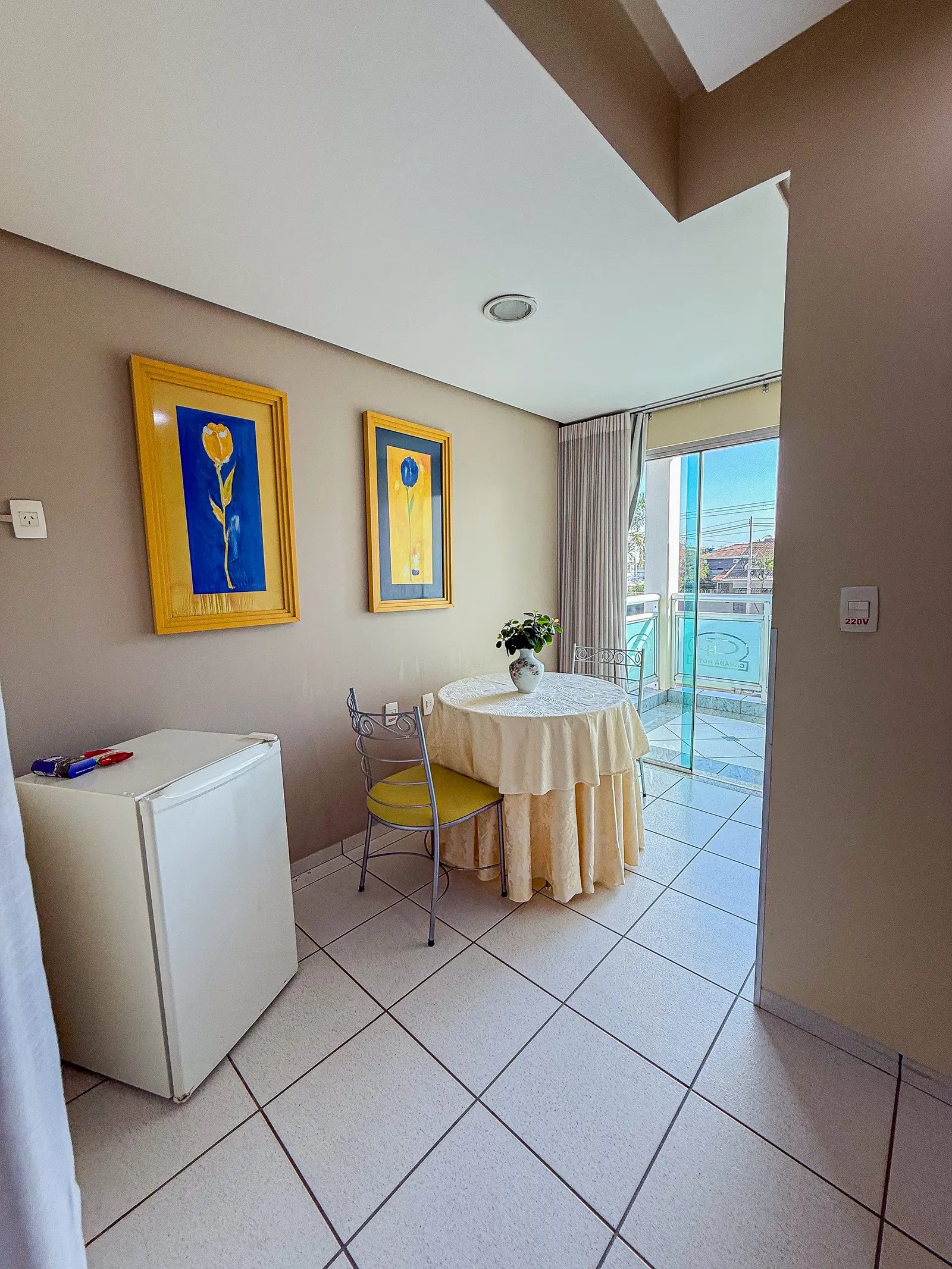 Suíte Master com frigobar e mesa junto à porta da varanda